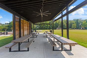 A row of picnic tables under a covered pavilion